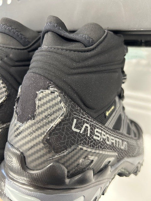 Close-up of a gray hiking shoe with visible branding on a blurred background